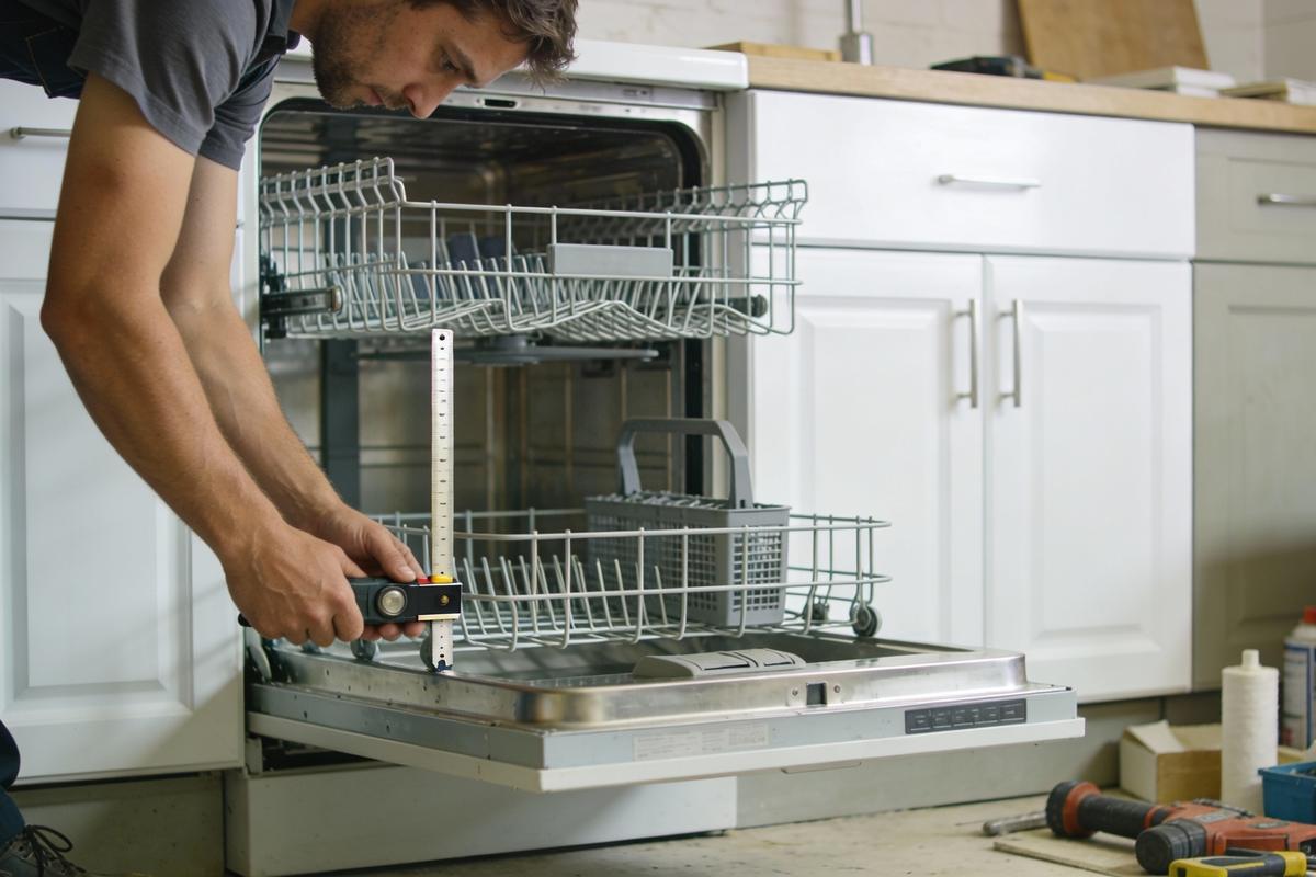 Technician working on a built-in kitchen dishwasher